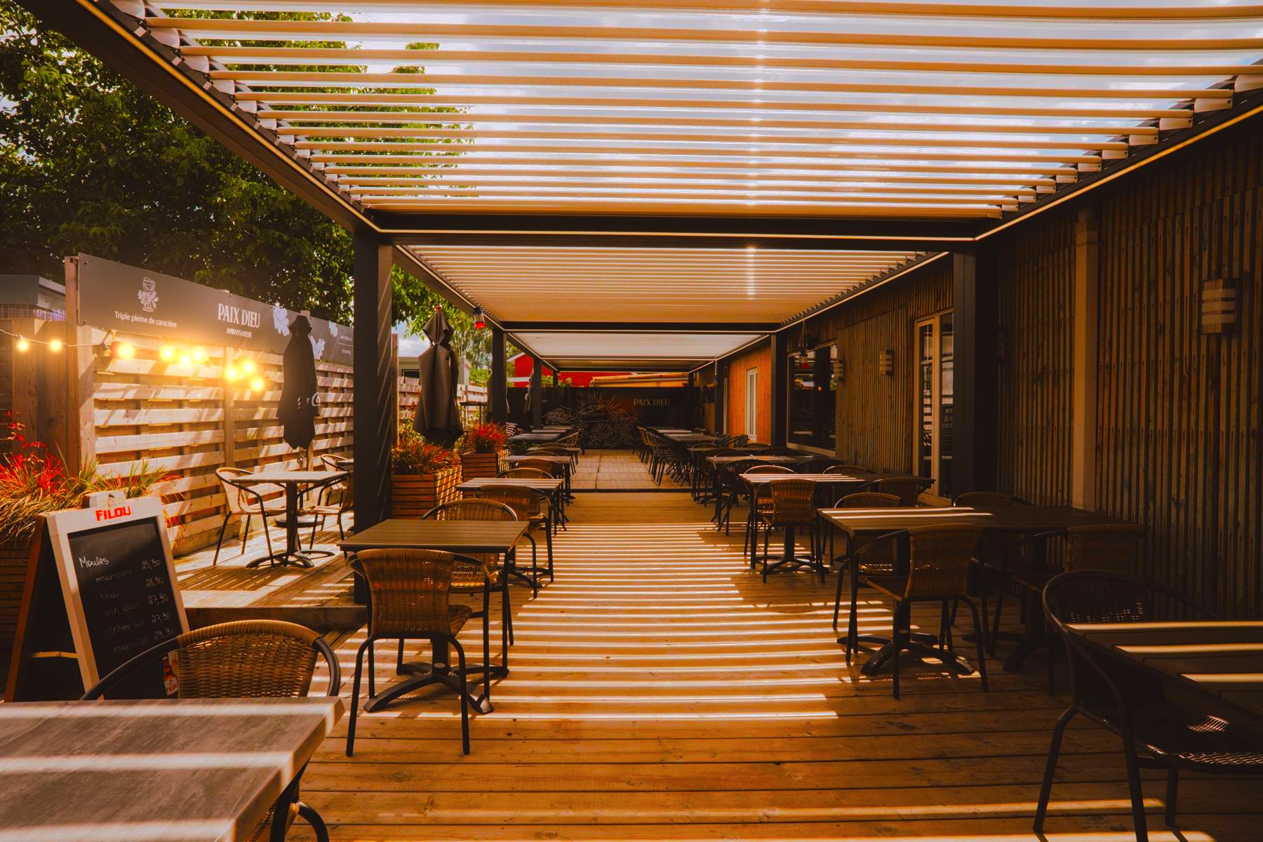 La grande terrasse en bois sous la pergola